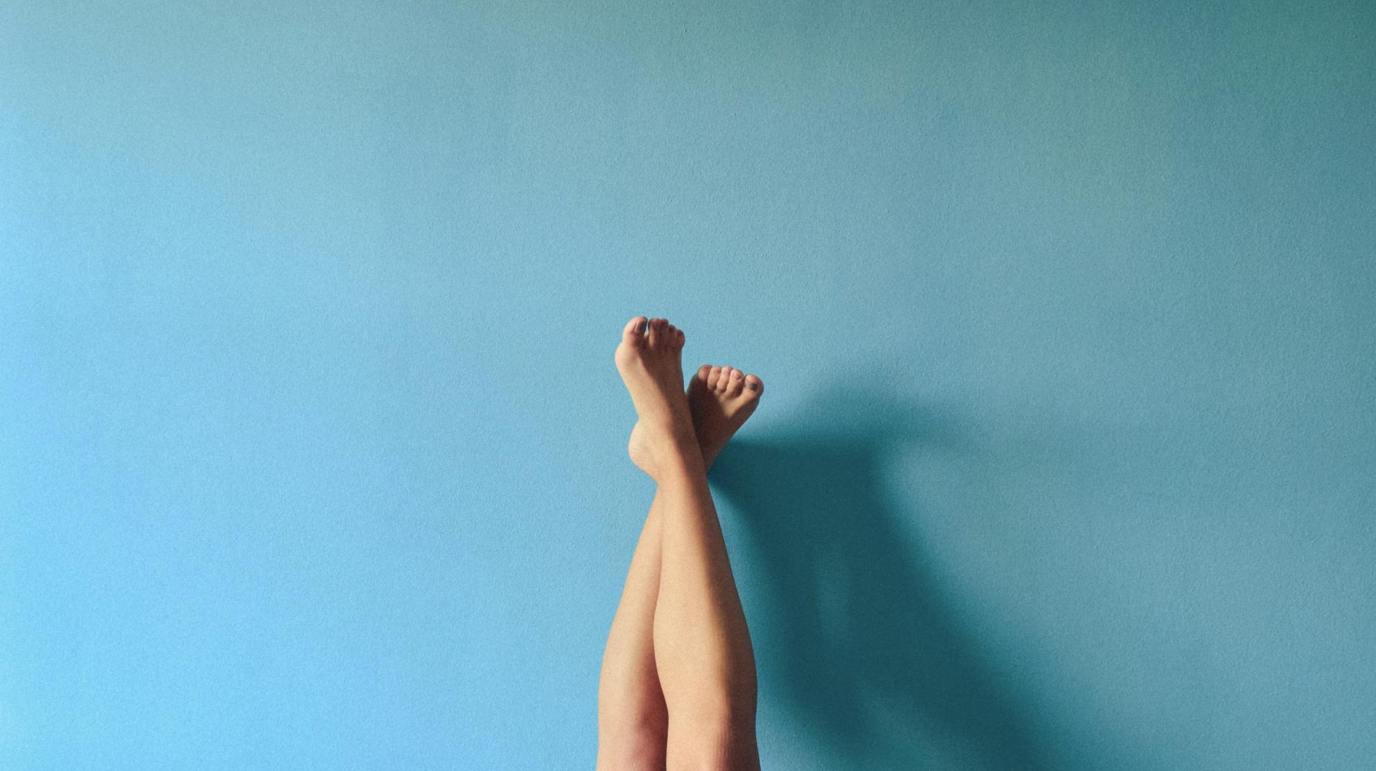 Woman's legs resting on a wall